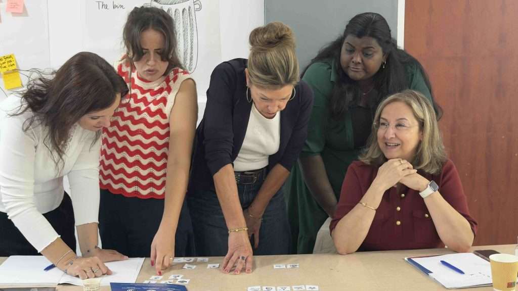 Enseignants de différents pays triant des cartes ensemble lors d’une activité coopérative de groupe sur la diversité culturelle en classe, Palerme